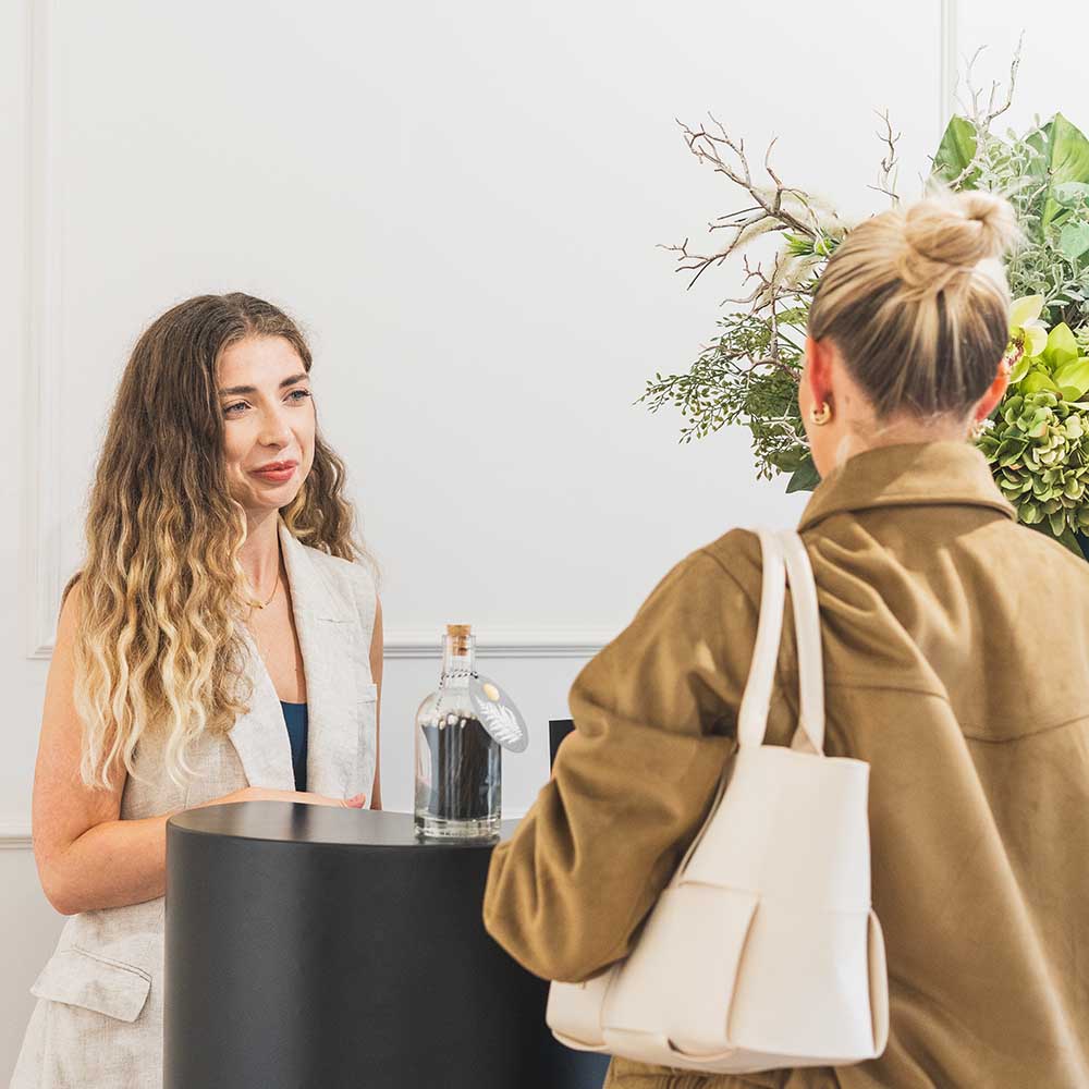 Two women interacting at a counter.