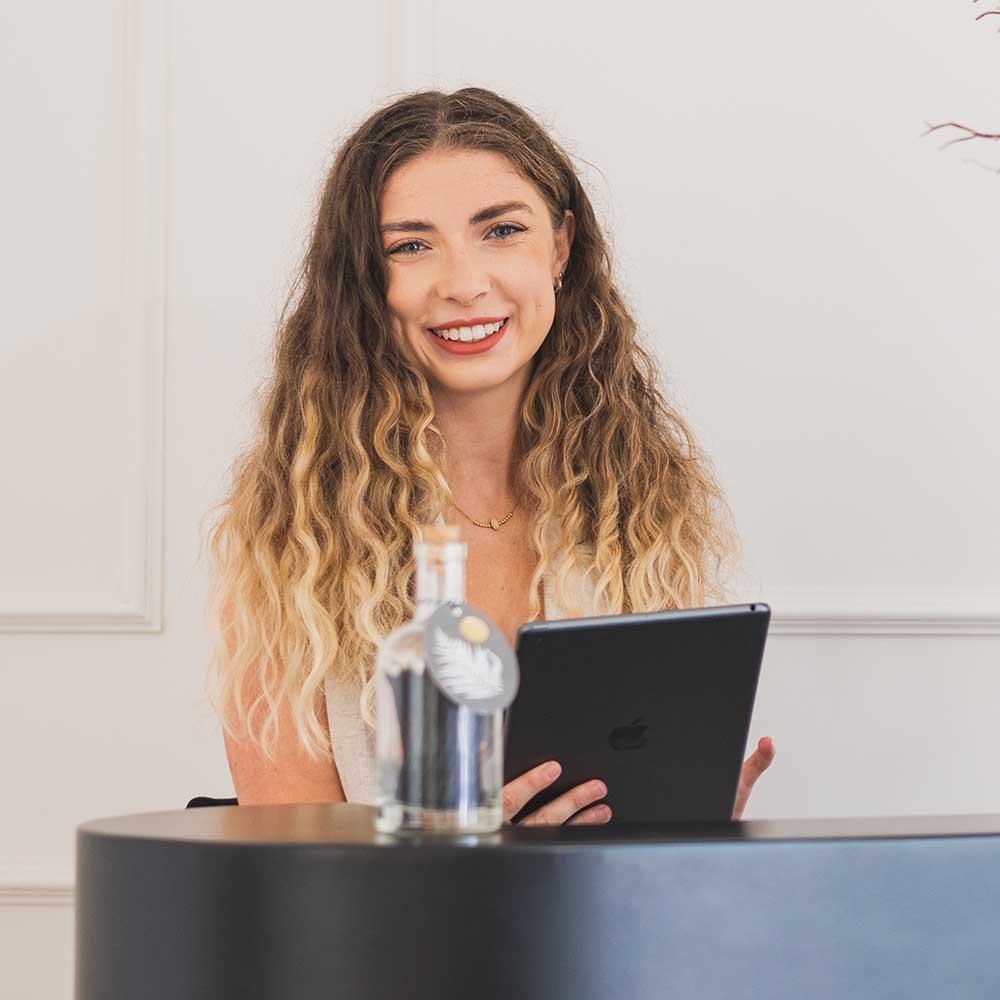 Woman with wavy hair holding a tablet computer in an indoor setting