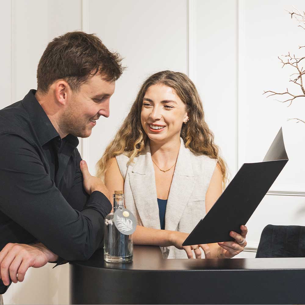 Two people looking at a laptop together in an office setting
