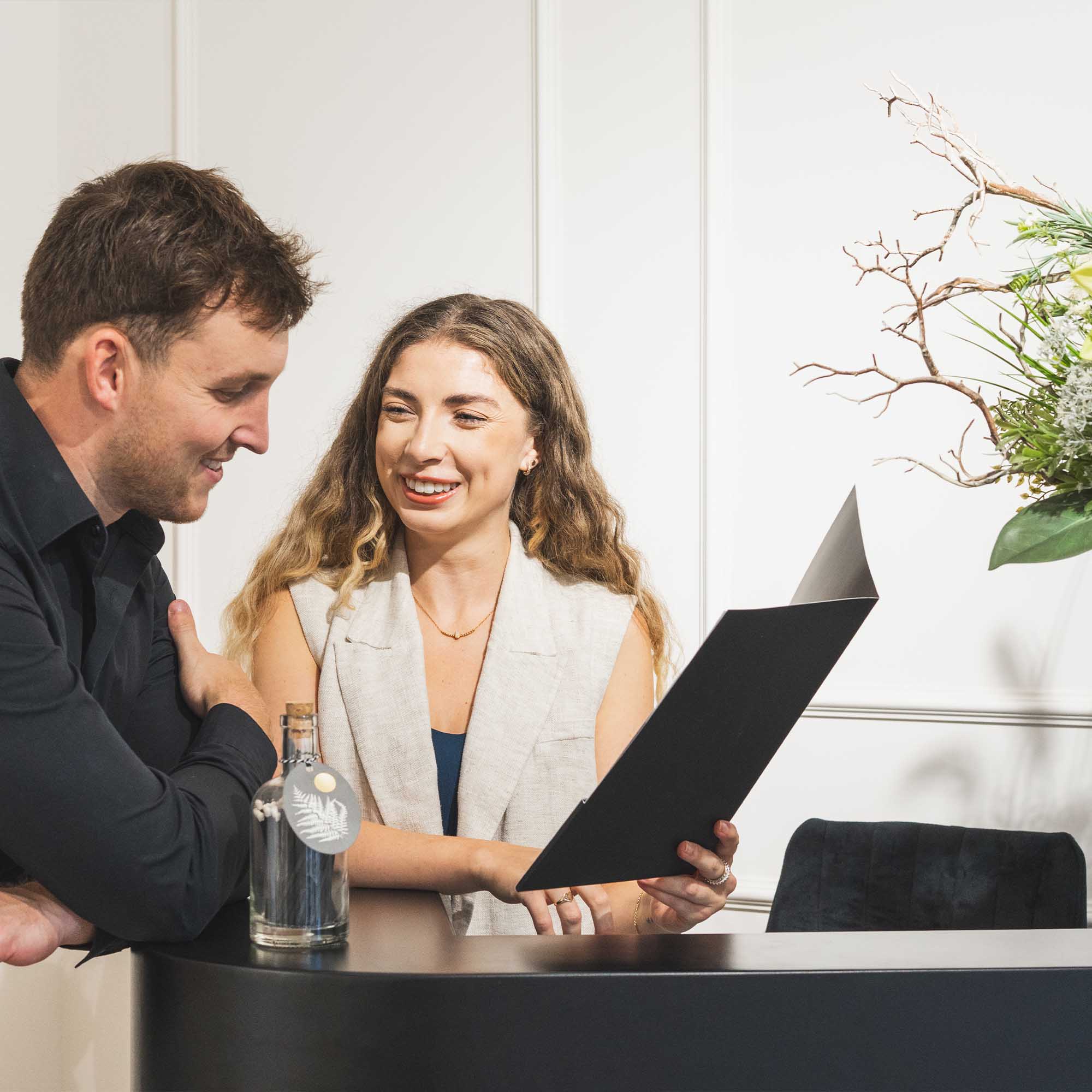 Two people looking at a laptop together in an office setting