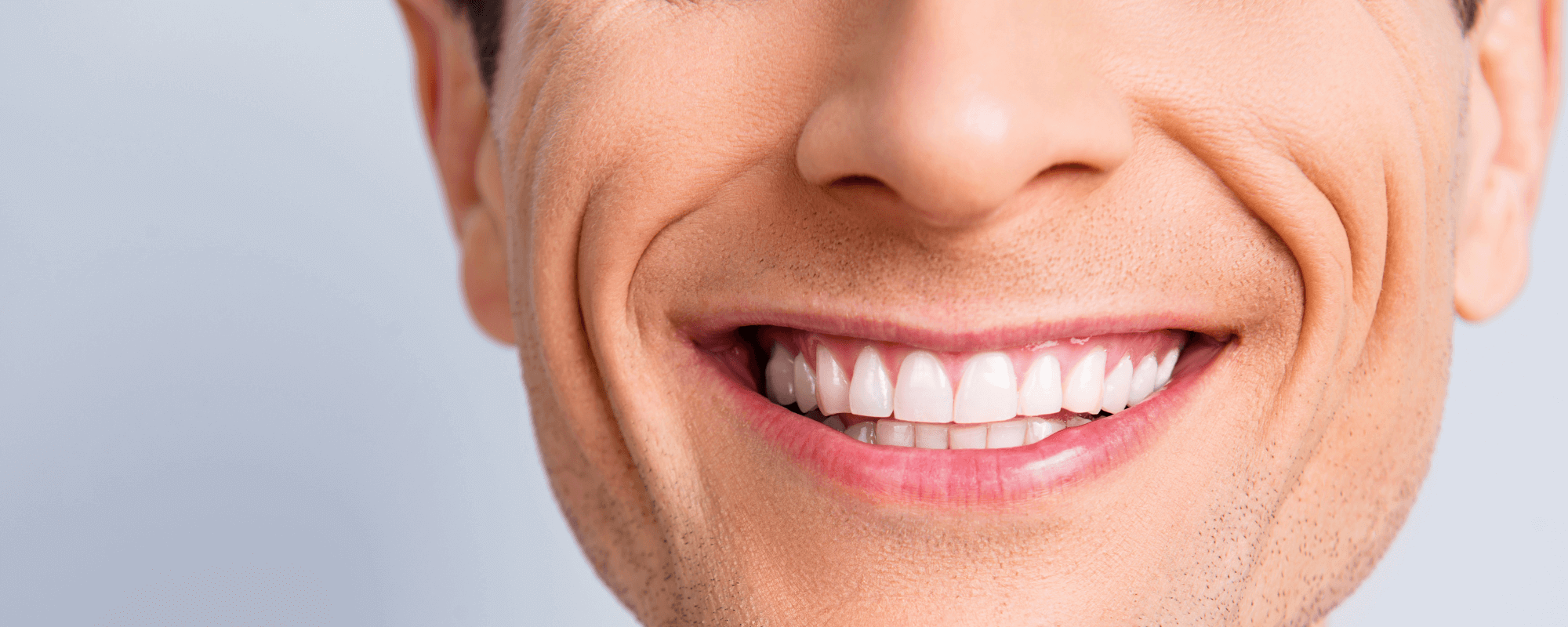 Man smiling with straight white teeth after having invisalign