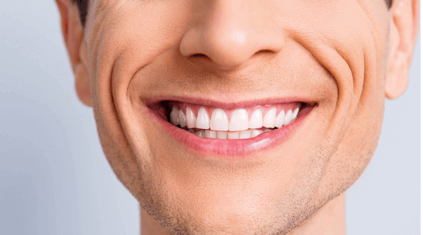 Man smiling with straight white teeth after having Invisalign